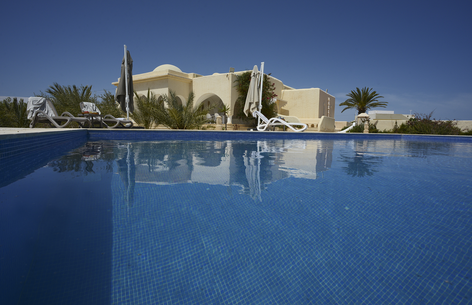 Propriété d'exception à vendre à Kerkennah. 5 000 m², 2 villas, piscine, rooftop vue mer, 30 m plage. 860 000 € FAI. Contactez Propriétés Clovis.