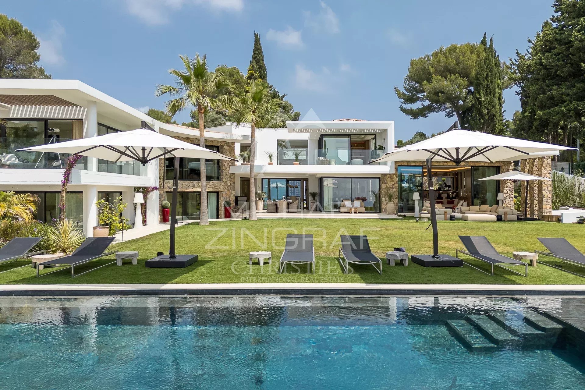 Villa contemporaine 660 m² en position dominante sur la baie de Cannes. 6 chambres en suite, piscine, sauna, hammam, vue panoramique mer. 53 000 €/semaine.