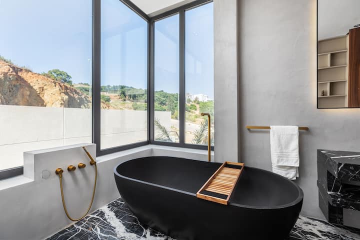 Salle de bains avec baignoire noire dans la villa à Tanger