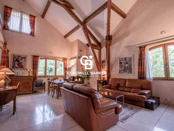 Intérieur d'une propriété spacieuse avec poutres apparentes et coin salon à Collonges-sous-Salève.