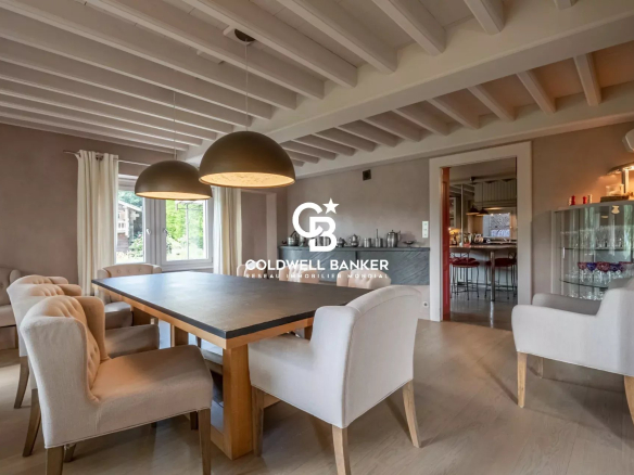 Intérieur d'une ferme rénovée à Arbusigny avec salle à manger, table et chaises modernes.