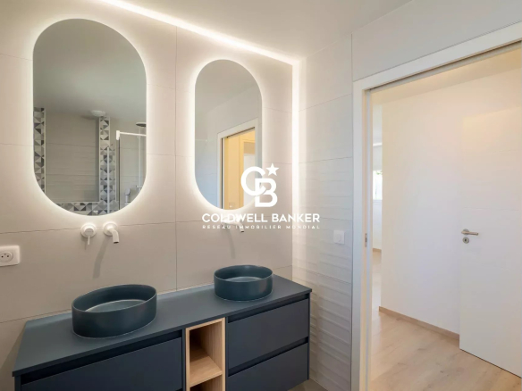 Modern bathroom with double sink and illuminated mirror in a new house.