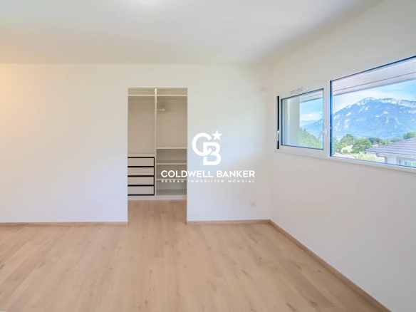 Interior of a new house in Etaux with mountain views, bright space and light parquet flooring.