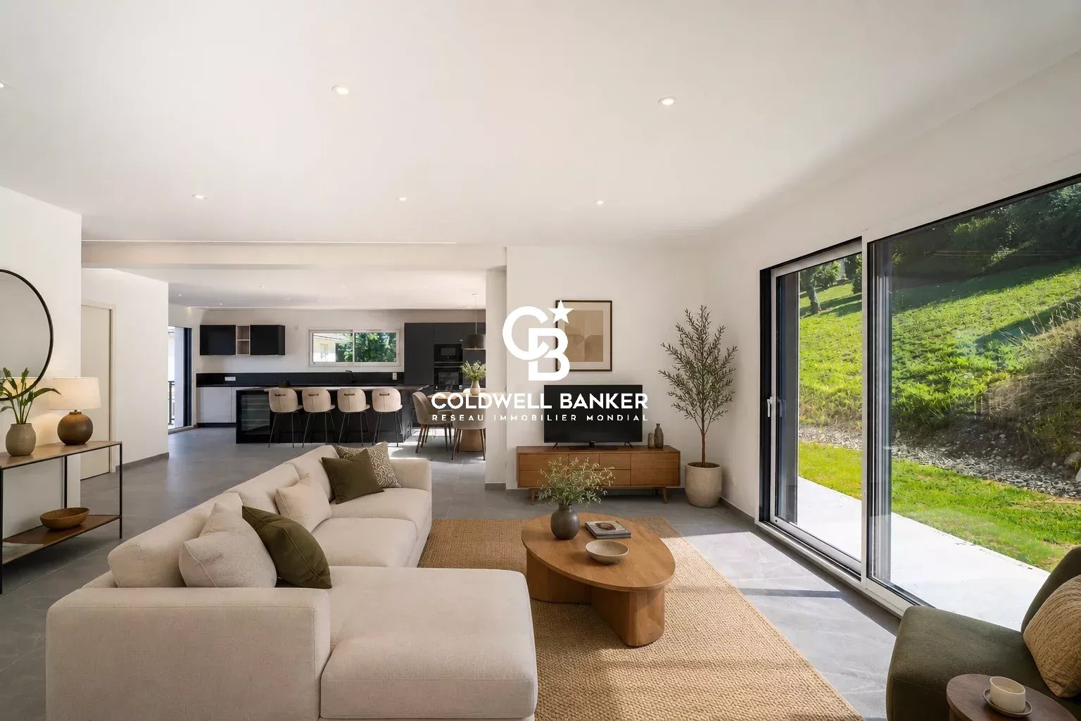 Modern living room of a house in Etaux Interior of a new house for sale, bright living room with sofa and access to the outside.