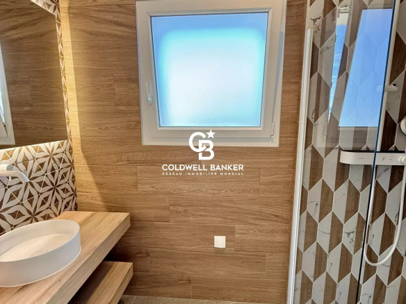 Modern bathroom with shower and sink, wood tiles and geometric patterns.