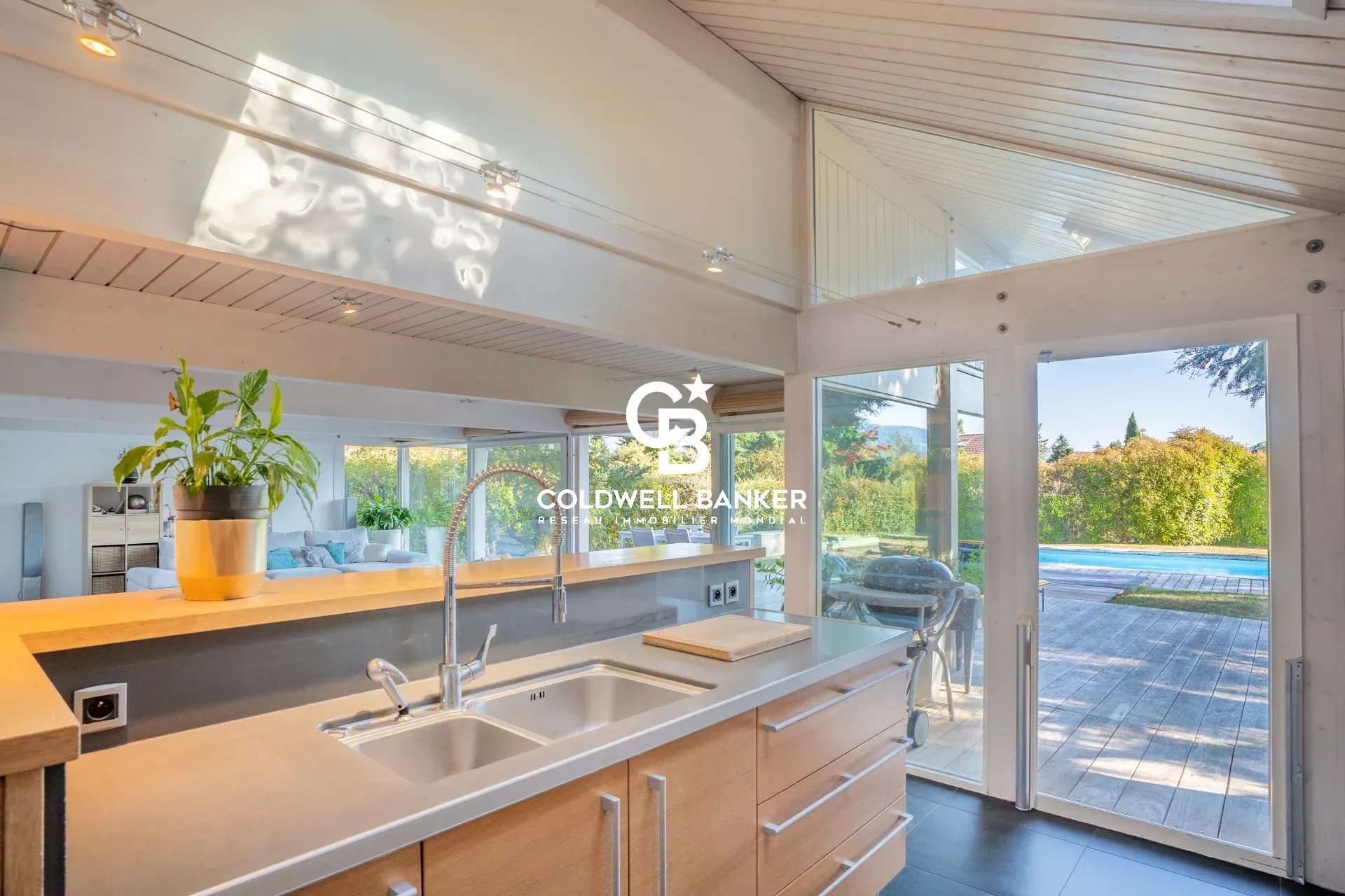 Cuisine lumineuse à Vétraz-Monthoux Cuisine moderne avec vue sur le jardin et la piscine dans une maison à Vétraz-Monthoux.