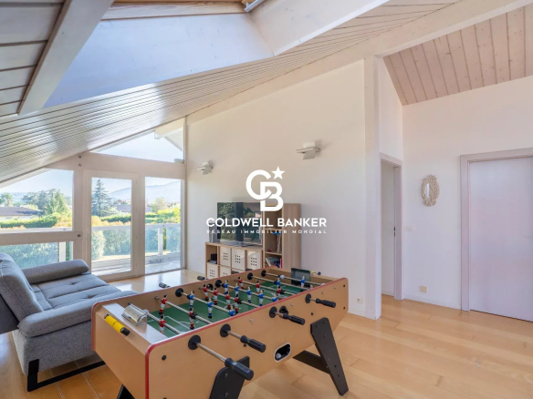 Intérieur d'une maison familiale à Vétraz-Monthoux avec un salon lumineux et une table de baby-foot.
