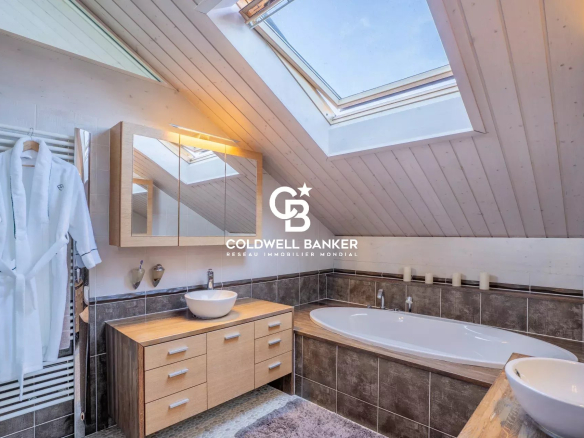 Salle de bain moderne avec baignoire et fenêtre de toit dans une maison familiale.