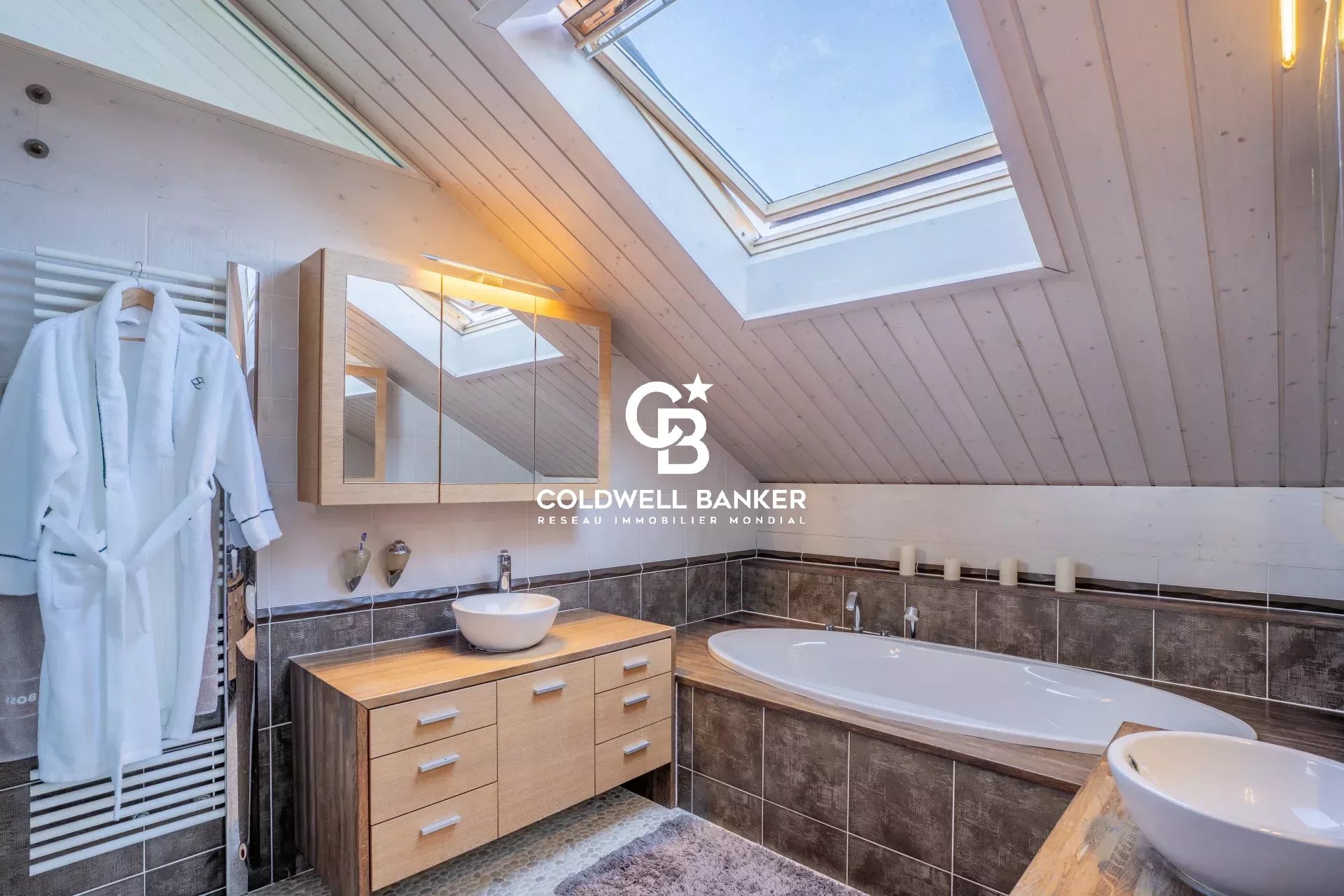Salle de bain moderne Salle de bain moderne avec baignoire et fenêtre de toit dans une maison familiale.