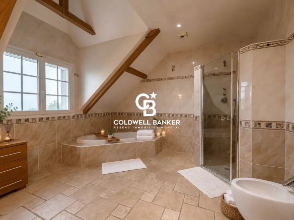 Salle de bain spacieuse avec baignoire et douche, murs carrelés, fenêtres et poutres apparentes.