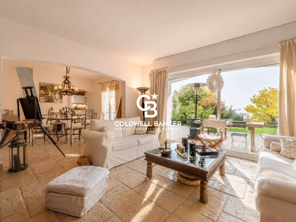 Intérieur d'une maison de prestige à Monnetier-Mornex avec salon lumineux et vue sur le jardin.