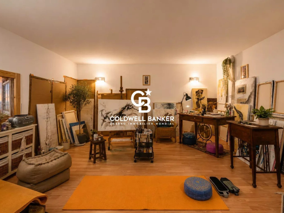 Intérieur d'un atelier d'art avec des fournitures et des œuvres, éclairé et spacieux.