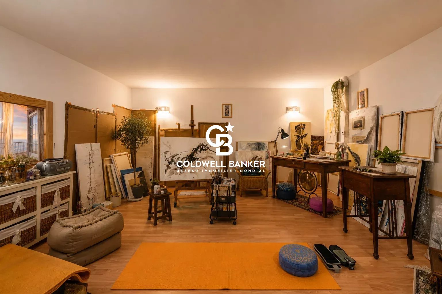 Intérieur d'un atelier d'art avec des fournitures et des œuvres, éclairé et spacieux.