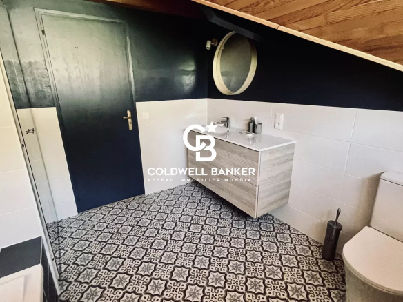 Salle de bain moderne avec carrelage décoratif et meuble lavabo.