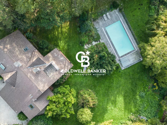 Vue aérienne d'une villa avec piscine sur un terrain verdoyant à Vétraz-Monthoux.