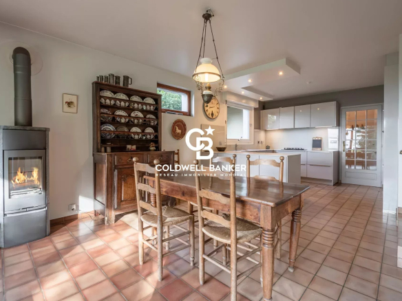 Cuisine d'une villa à Vétraz-Monthoux avec table en bois et poêle à bois.