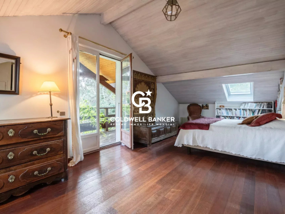Chambre d'une villa à Vétraz-Monthoux avec parquet en bois et accès à un balcon.
