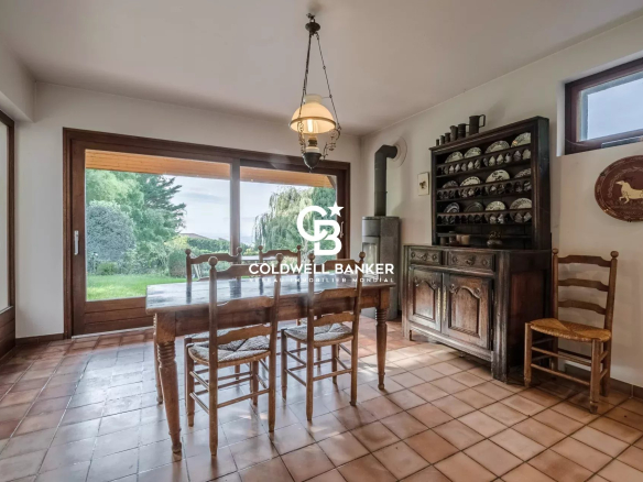 Intérieur d'une villa à Vétraz-Monthoux avec une salle à manger en bois et vue sur le jardin.