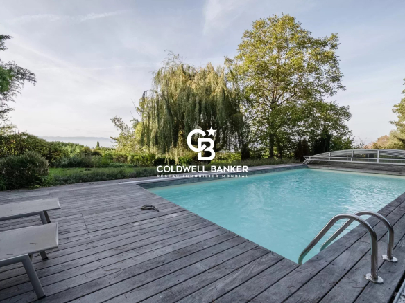 Piscine extérieure en bois avec vue sur la verdure et le ciel à Vétraz-Monthoux.