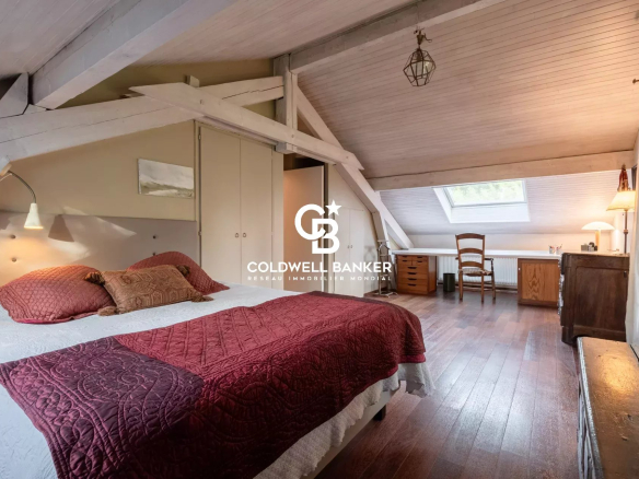 Chambre spacieuse avec lit et mobilier en bois dans une villa à Vétraz-Monthoux.