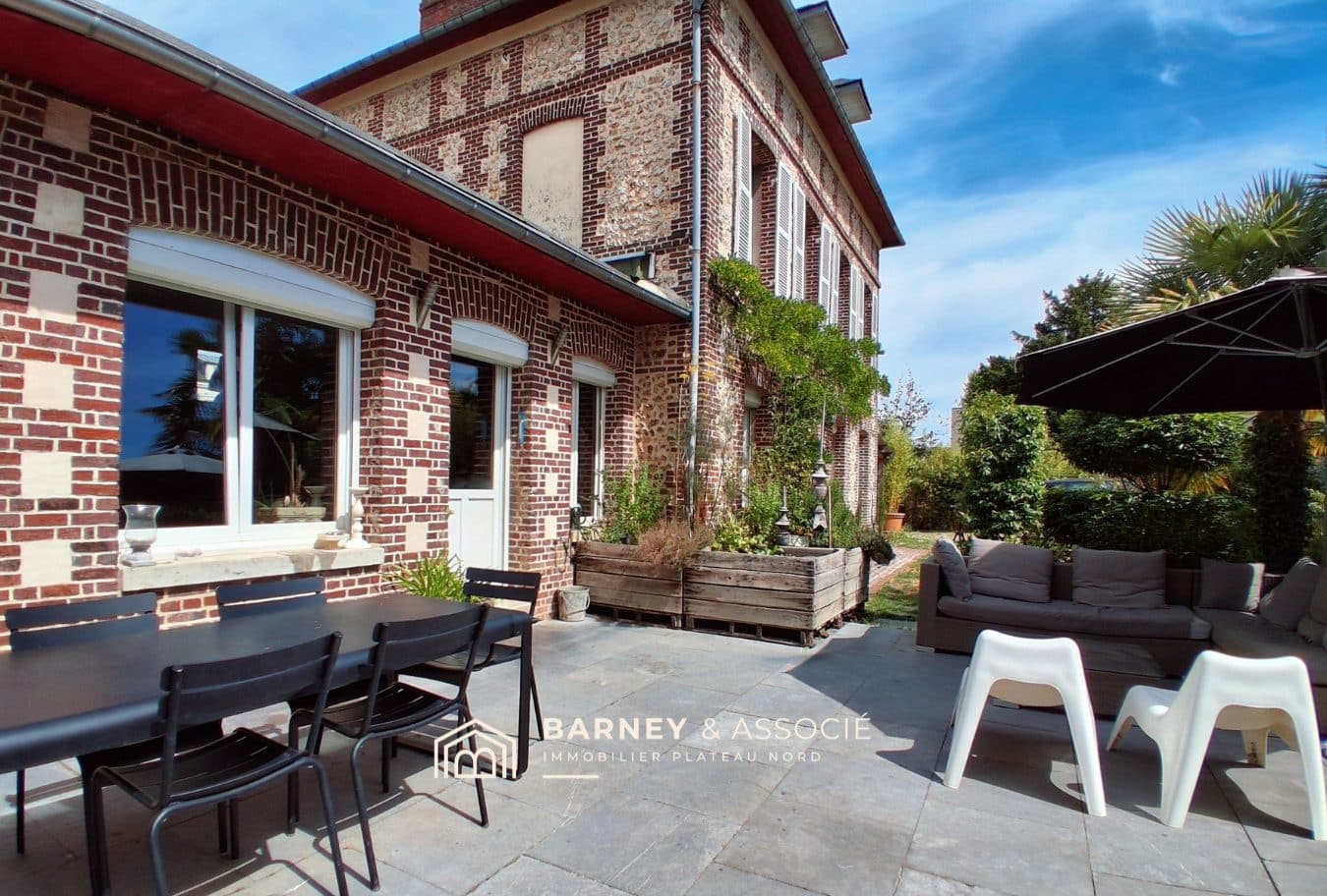 Maison ancienne en brique et silex avec terrasse et mobilier extérieur à Bihorel.