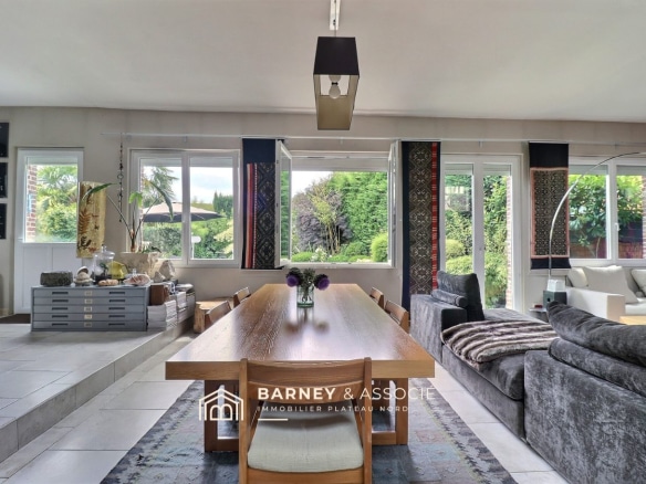 Intérieur d'une maison ancienne rénovée avec une grande pièce de vie lumineuse et vue sur le jardin.