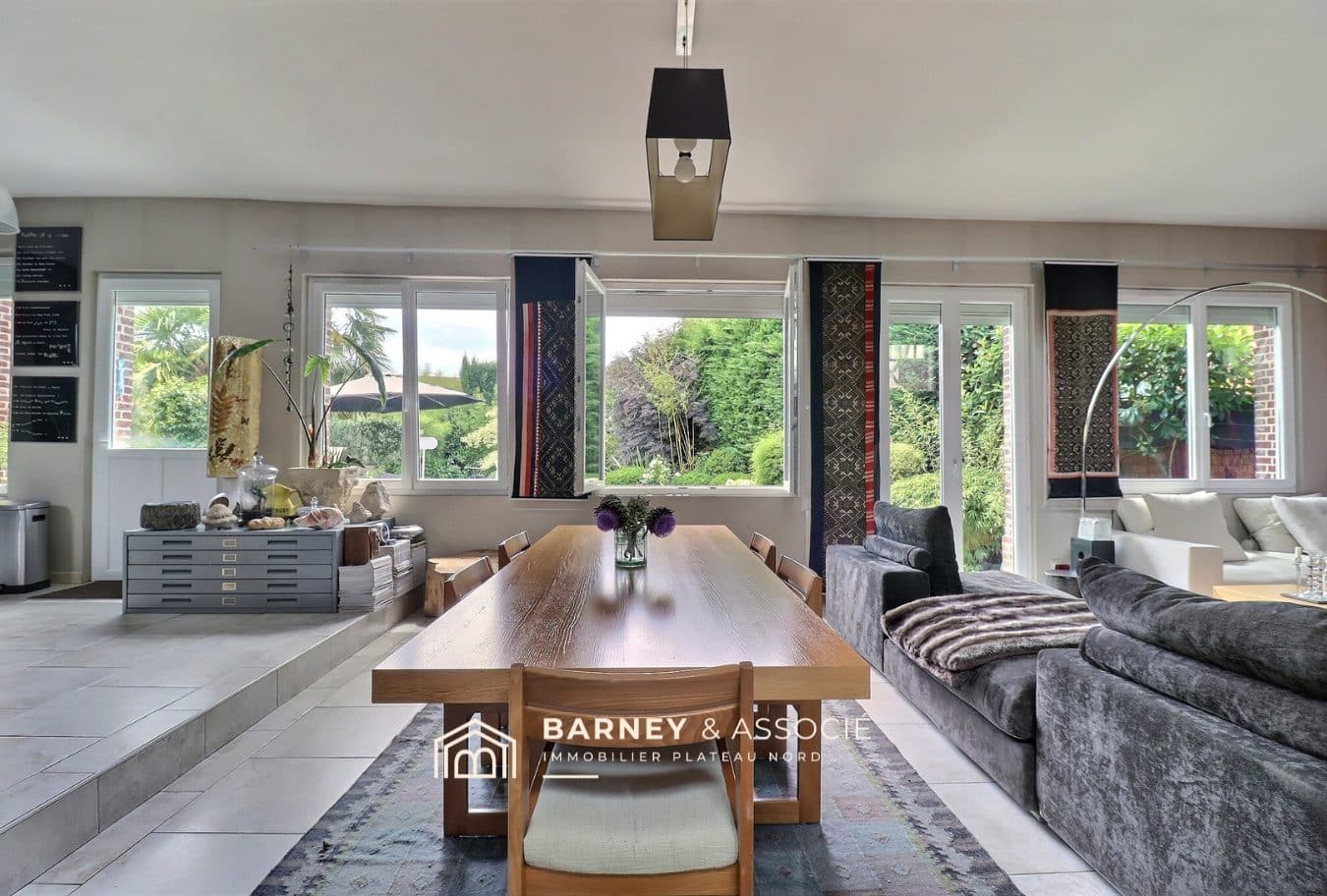 Intérieur d'une maison ancienne rénovée avec une grande pièce de vie lumineuse et vue sur le jardin.