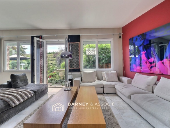 Intérieur d'une maison ancienne avec salon lumineux et vue sur le jardin.