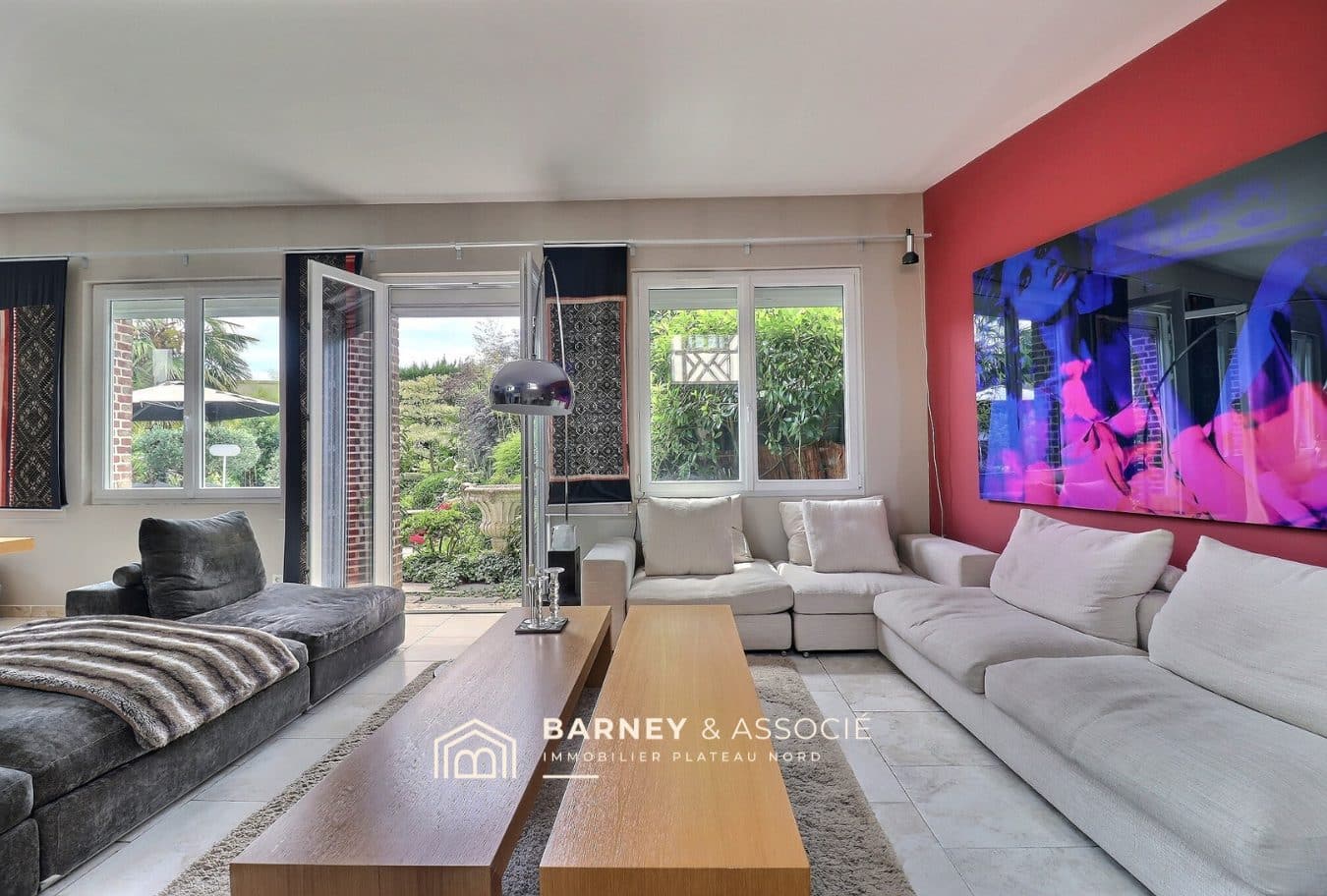 Intérieur d'une maison ancienne avec salon lumineux et vue sur le jardin.