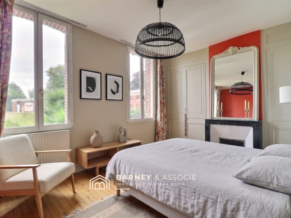 Chambre d'une maison ancienne rénovée avec un lit, une chaise et une cheminée.