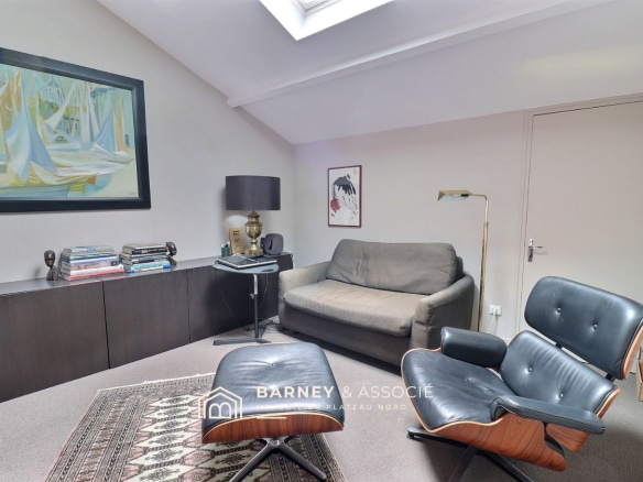 Intérieur d'un bureau dans une maison d'architecte à Mont-Saint-Aignan, avec canapé et fauteuil.