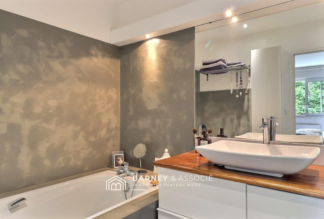 Salle de bain de la maison familiale Salle de bain moderne avec baignoire et lavabo sur un plan en bois.