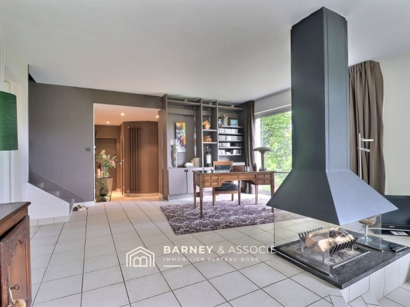 Intérieur d'une maison d'architecte avec salon, bureau et cheminée.