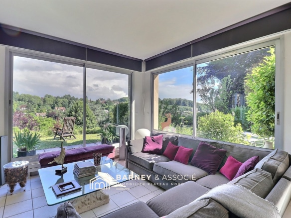 Intérieur d'une maison moderne avec vue sur la nature, salon lumineux et confortable.