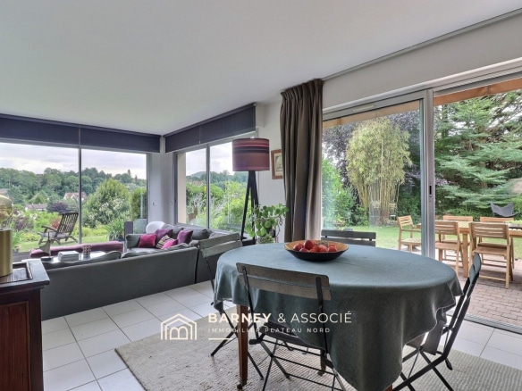 Intérieur d'une maison d'architecte avec salon et salle à manger, vue sur le jardin.