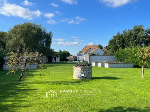 Jardin d'une maison de campagne avec pelouse bien entretenue et piscine, à Vironvay.