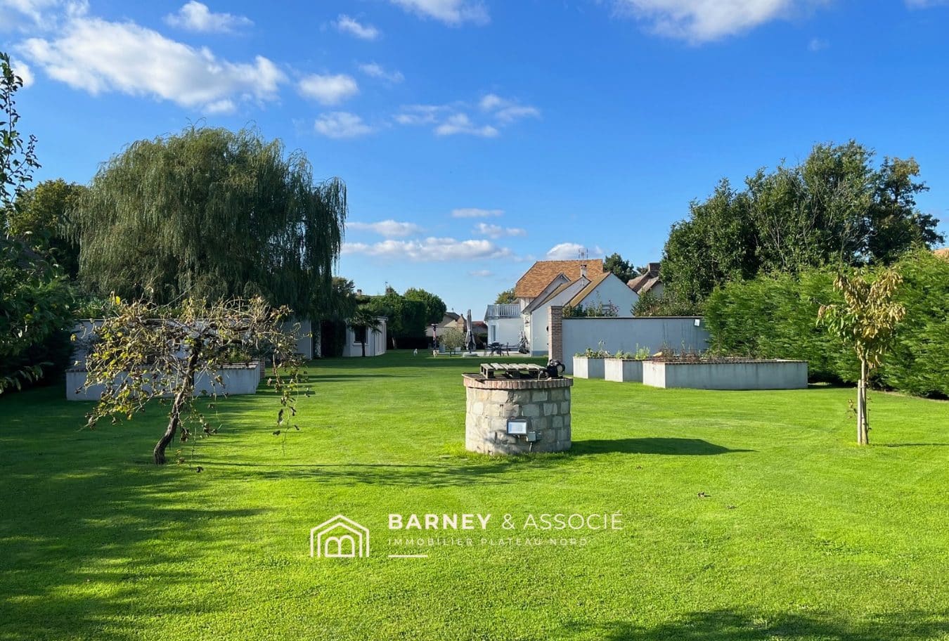 Jardin d'une maison de campagne avec pelouse bien entretenue et piscine, à Vironvay.