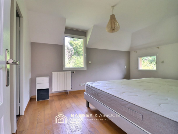 Chambre d'une maison d'architecte à Mont-Saint-Aignan avec un lit et une fenêtre.