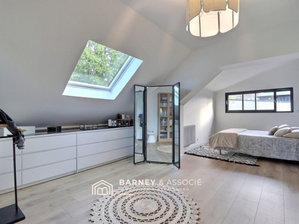 Chambre lumineuse avec velux et mobilier moderne dans une maison rénovée à Bois-Guillaume.
