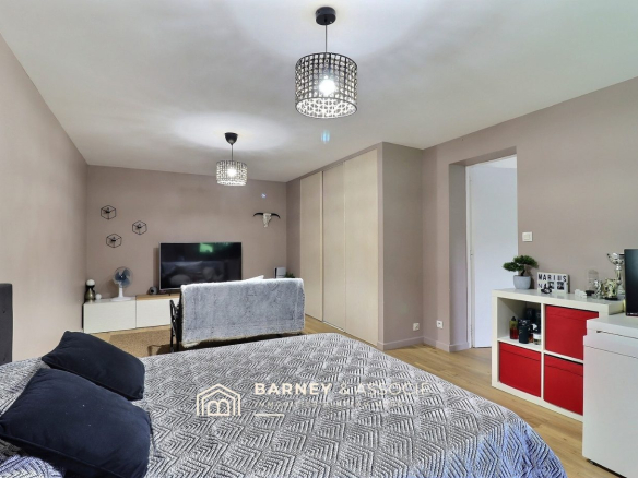 Chambre d'une maison rénovée avec décoration moderne et télévision.