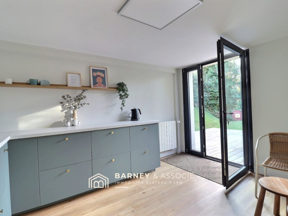 Intérieur d'une maison rénovée avec cuisine aménagée et accès à l'extérieur.