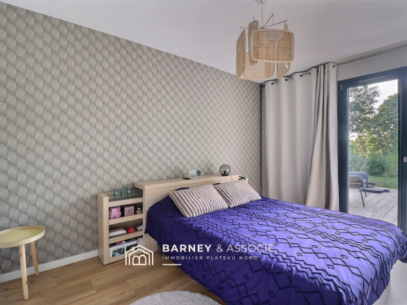 Chambre d'une maison rénovée avec un lit et un accès à l'extérieur.