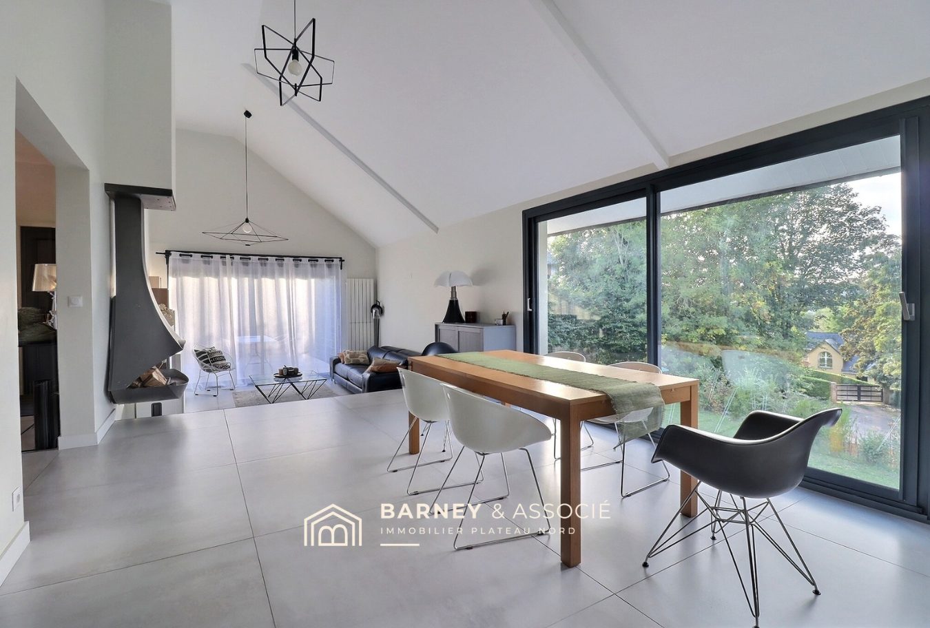 Intérieur d’une maison rénovée Intérieur d'une maison rénovée avec salon, salle à manger et grandes fenêtres donnant sur le jardin.