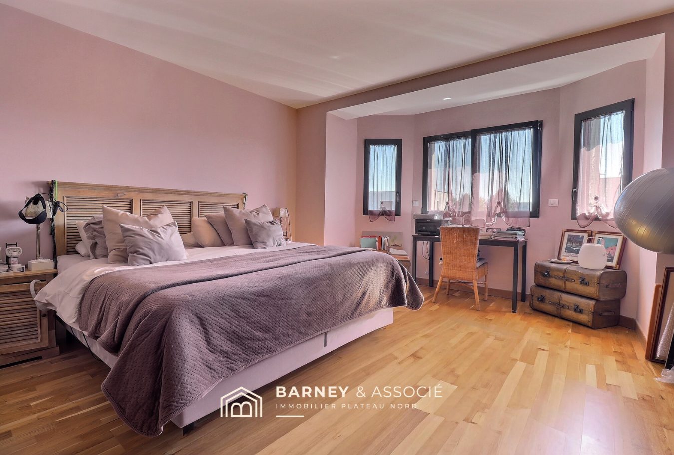 Chambre contemporaine Chambre spacieuse avec lit double et bureau, murs en rose et fenêtres avec rideaux