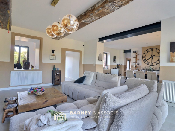 Intérieur d'une maison rénovée avec salon et salle à manger, décoration moderne et lumineuse.
