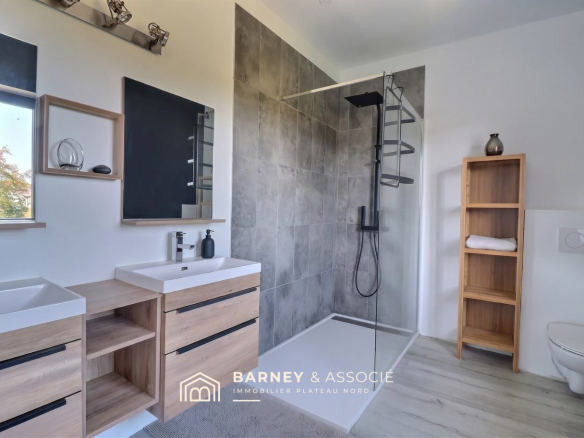 Salle de bain moderne avec douche à l'italienne et meubles en bois.