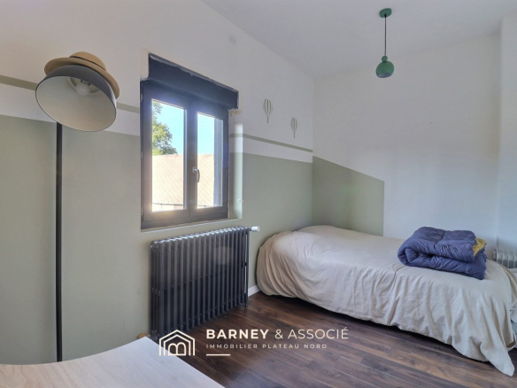 Chambre d'une maison rénovée avec lit simple et décoration sobre à Esclavelles.