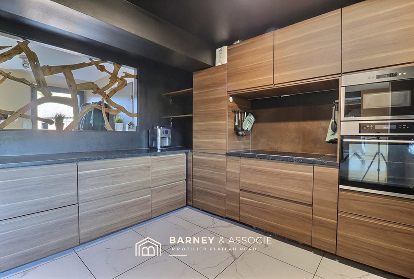 Cuisine moderne avec meubles en bois et équipements intégrés dans une propriété équestre.