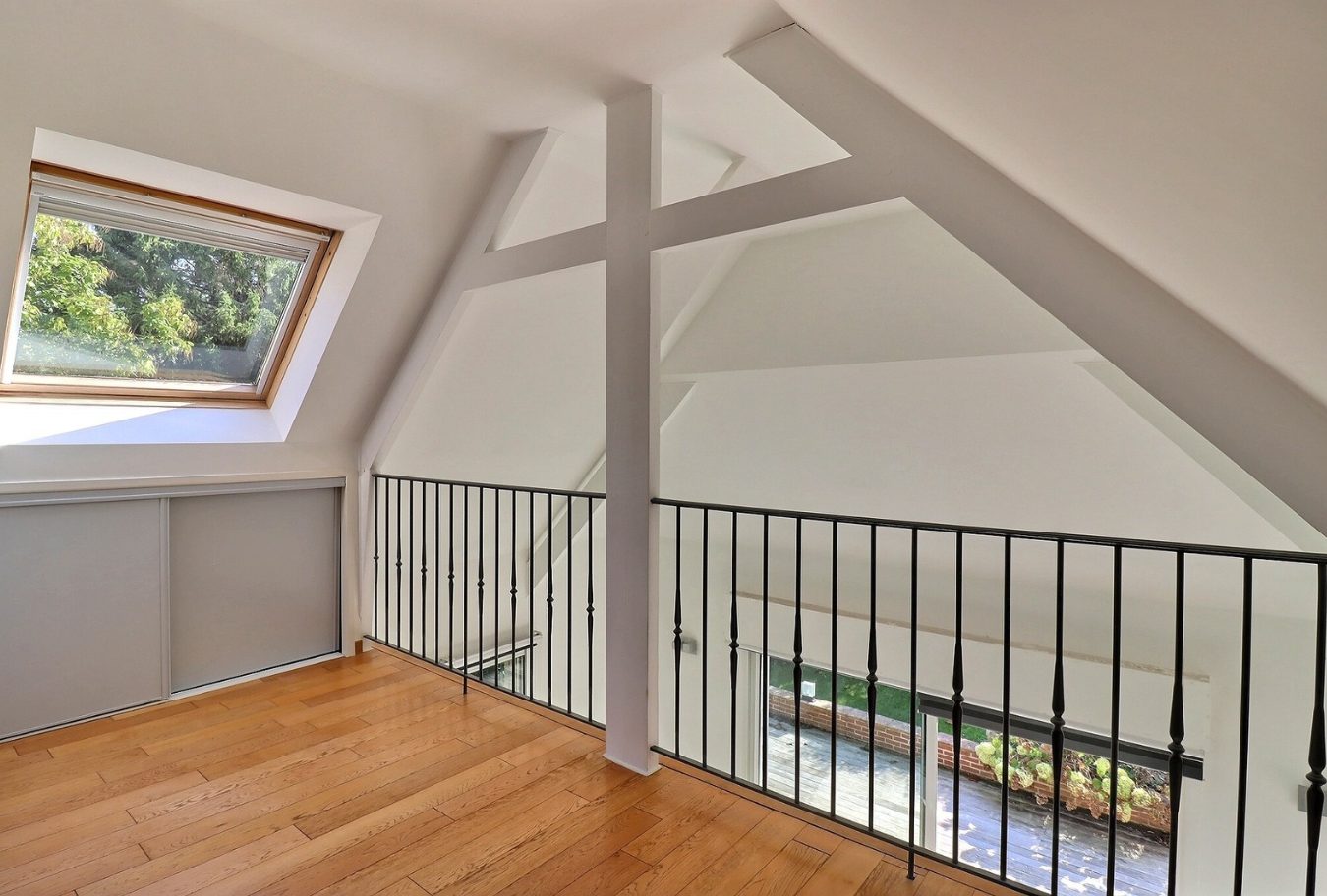 Intérieur d'une maison d'architecte avec un grand espace lumineux et une vue sur le jardin.
