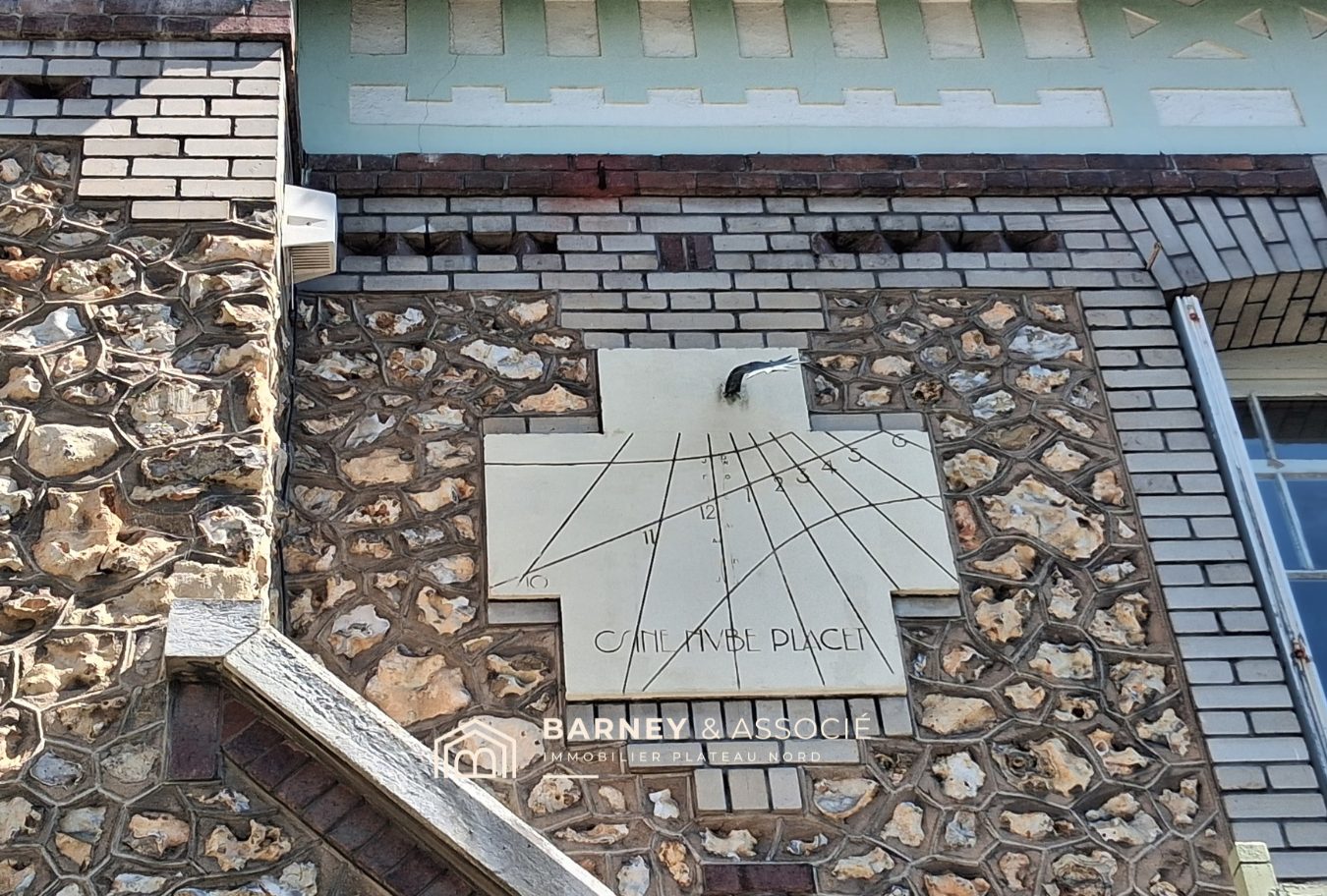 Cadran solaire sur une maison bourgeoise Sundial on the facade of a bourgeois house in Mont-Saint-Aignan, showcasing brick and flint architecture.